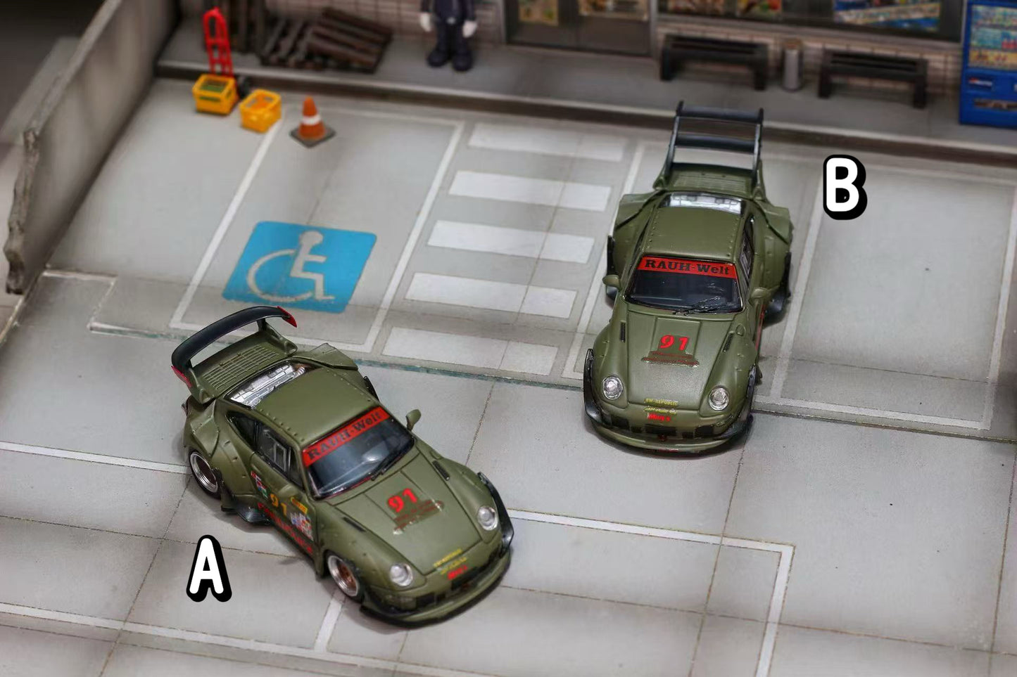 Two model cars on a platform with a disabled access sign in the background