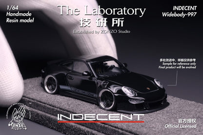 Model car of a black sports car on a gray surface with 'INDECENT' branding.
