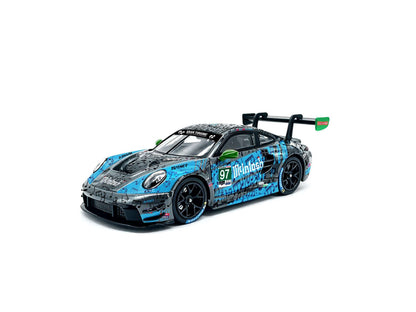 JICAR 1:64 Porsche 911 GT3 R #97 Turner Motorsport Multitask blue and black racing diecast model featuring musical note livery, green side mirrors, black racing wheels and large rear wing, front three-quarter view.