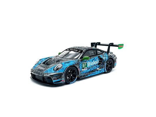 JICAR 1:64 Porsche 911 GT3 R #97 Turner Motorsport Multitask blue and black racing diecast model featuring musical note livery, green side mirrors, black racing wheels and large rear wing, front three-quarter view.