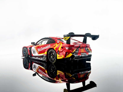JICAR 1:64 M4 GT3 EVO #31 Red & Yellow Fast Food Racing Livery diecast model featuring red and yellow graphics, black racing wheels, large rear wing, detailed taillights and rear diffuser, rear three-quarter view.