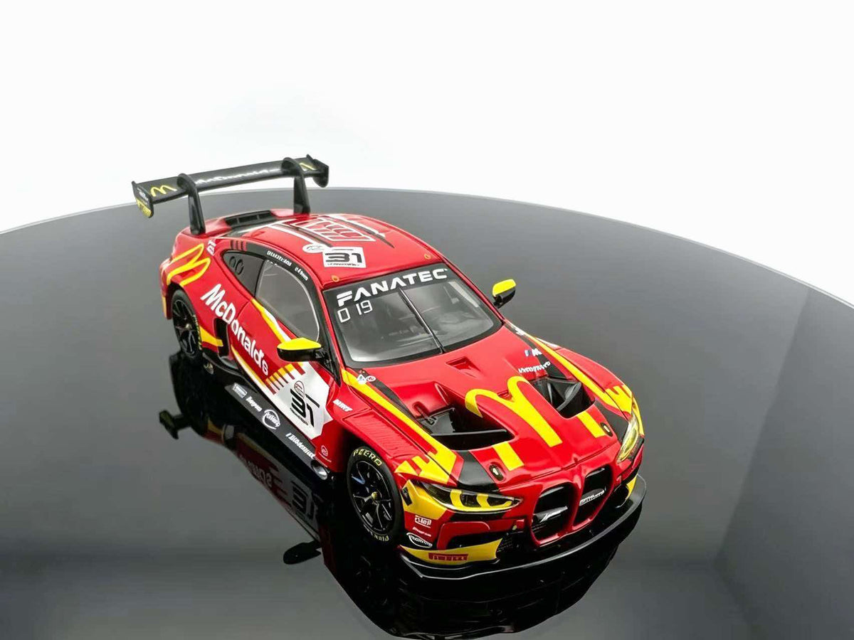 JICAR 1:64 M4 GT3 EVO #31 Red & Yellow Fast Food Racing Livery diecast model featuring red and yellow racing graphics, black racing wheels, large rear wing, detailed front grille and aerodynamic body kit, elevated front three-quarter view.
