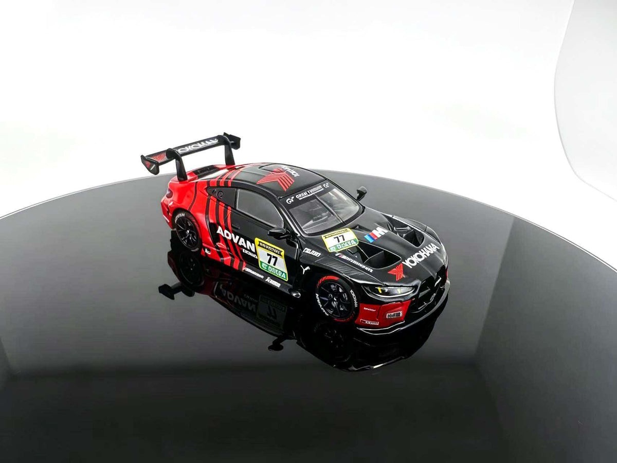 JICAR 1:64 M4 GT3 EVO #77 Black & Red Racing Livery diecast model featuring ADVAN-style graphics, black racing wheels, detailed hood vents, aerodynamic front splitter and large rear wing, elevated front three-quarter view.