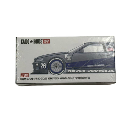 Kaido House Koshō Works 1/64 scale diecast model car packaging for the 2026 Malaysia Nissan Skyline GT-R (R34) exclusive, featuring a blue and white race car illustration on a white box.