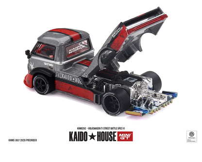 A miniature model of a Kaido House Volkswagen T1 street battle spec V8 truck, shown in a detailed layout with the rear hatch open to reveal a highly detailed engine bay. The model features a metallic silver body with red stripes and black accents, set against a clean white background with product details printed below.