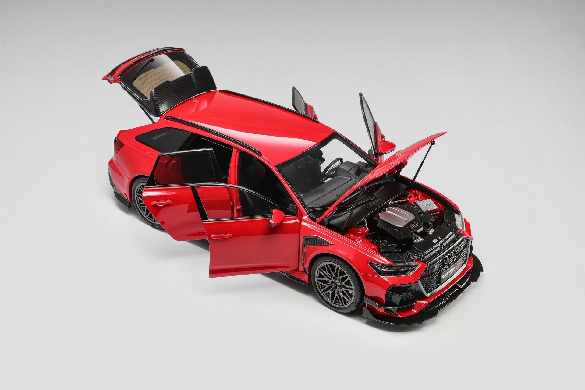Red car with open doors and hood on a gray background