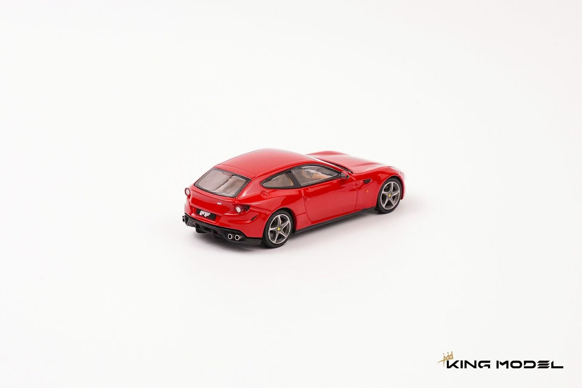 King Model 1:64 Ferrari FF in Rosso Corsa red featuring silver five-spoke wheels, yellow brake calipers, quad exhaust tips, and a tan leather interior. Premium diecast model displayed in a rear three-quarter view on a clean studio background, showcasing its distinctive shooting brake styling.