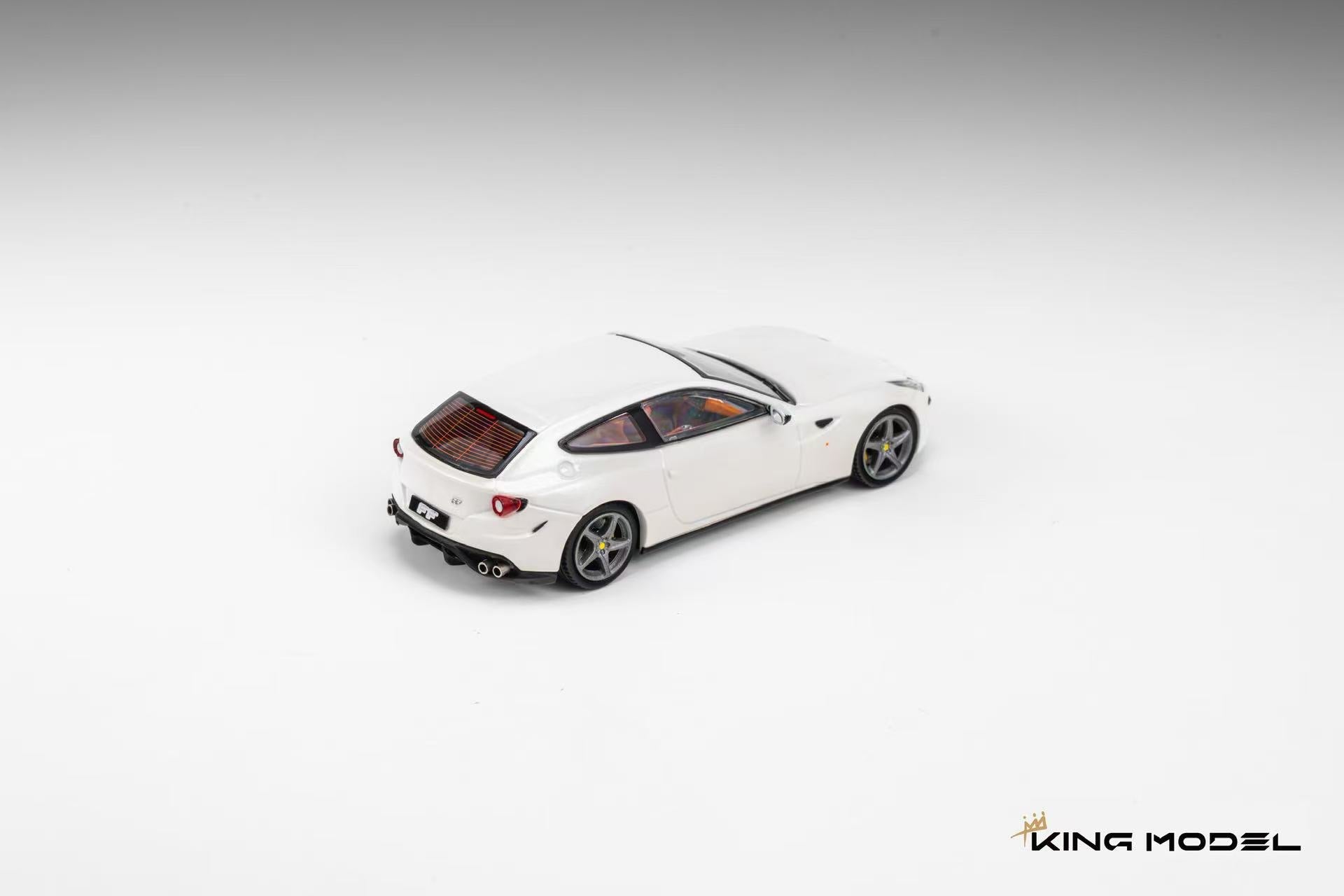 King Model 1:64 Ferrari FF in Bianco Avus white featuring silver five-spoke wheels, yellow brake calipers, quad exhaust tips, and a tan leather interior. Premium diecast model displayed in a rear three-quarter view on a clean studio background, highlighting its elegant shooting brake design.