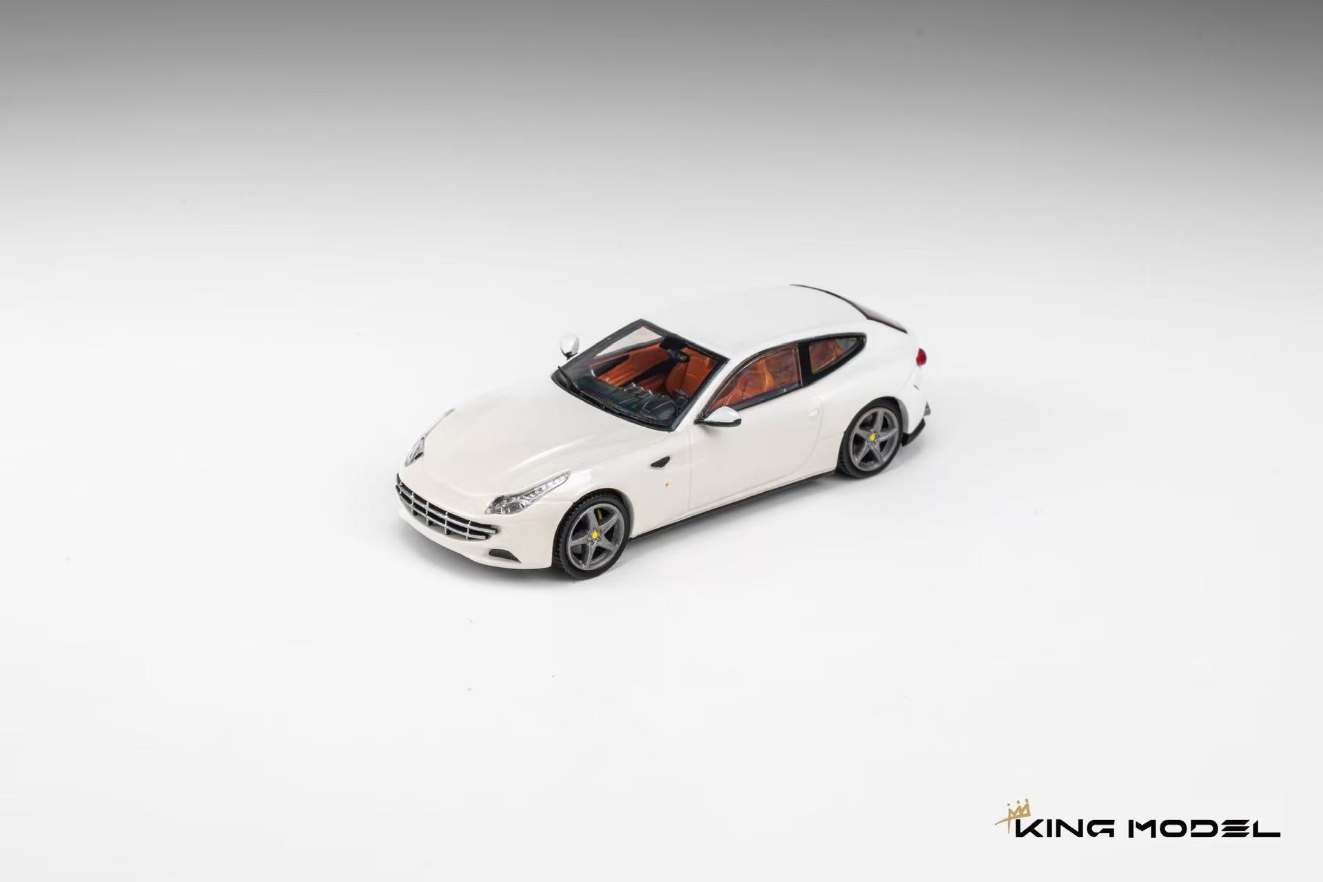 King Model 1:64 Ferrari FF in Bianco Avus white featuring silver five-spoke wheels, yellow brake calipers, tan leather interior, and elegant grand touring proportions. Premium diecast model shown in a front three-quarter view on a clean studio background, highlighting its four-seat shooting brake design.