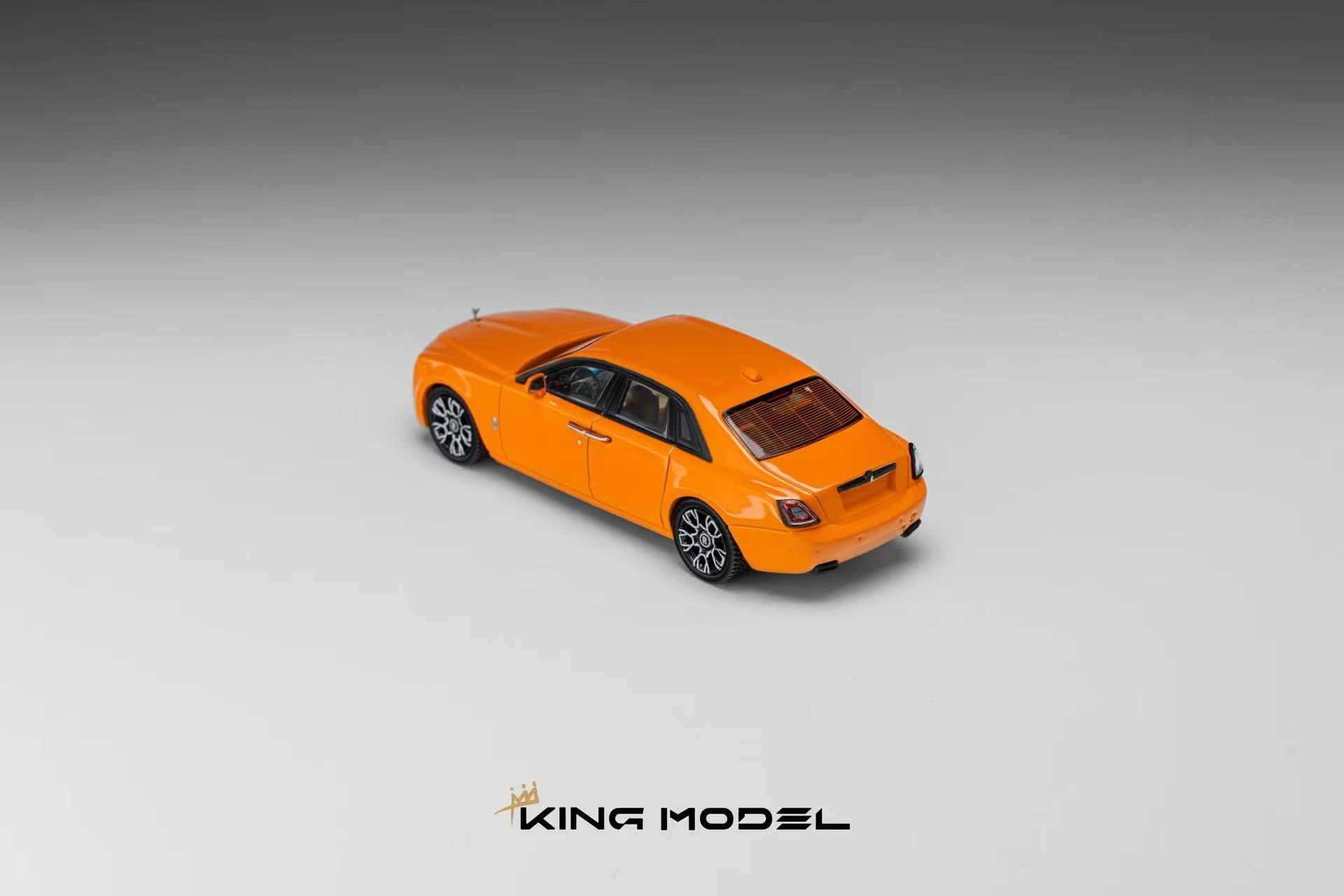 An orange model car, resembling a luxury sedan, shown from a three-quarters rear angle on a gray gradient background with the brand name 'KING MODEL' at the bottom.