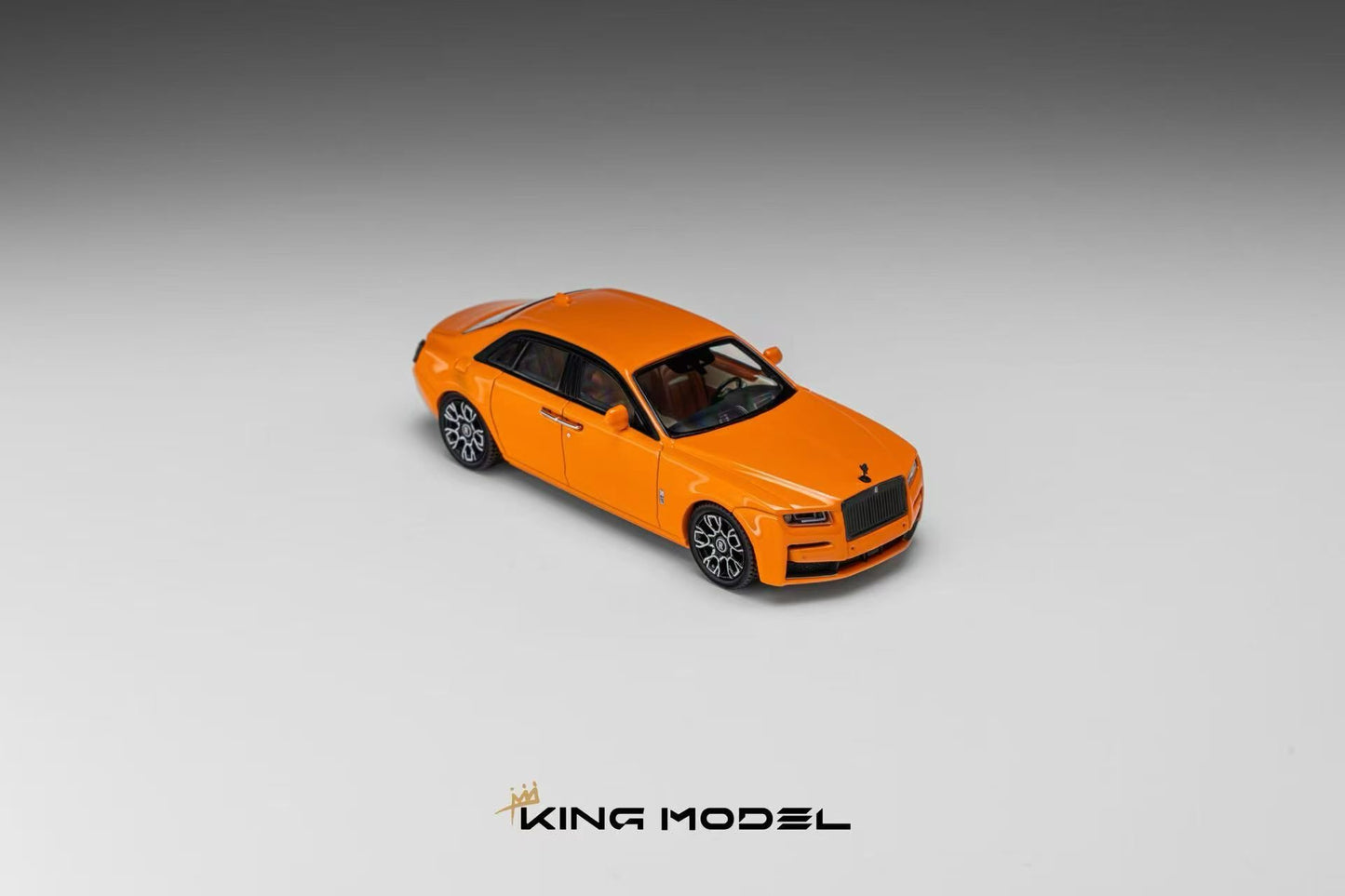 An orange diecast model car resembling a Rolls-Royce, shown from a three-quarters front angle on a gray gradient background with the 'KING MODEL' logo at the bottom.