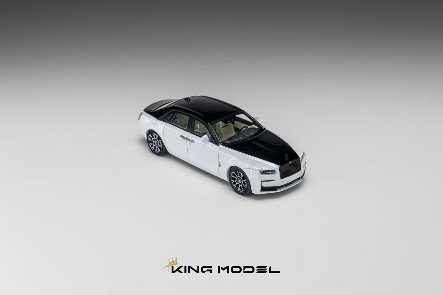 A miniature model of a Rolls-Royce Ghost sedan in a two-tone white and black livery, shown from a three-quarters perspective on a neutral gray gradient background with the 'KING MODEL' logo at the bottom.
