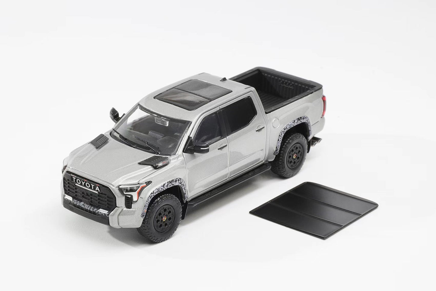 Model toy truck with open bed on a white background