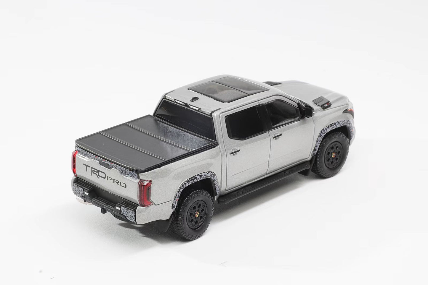 Model of a silver truck with a TONPROR cover on a white background