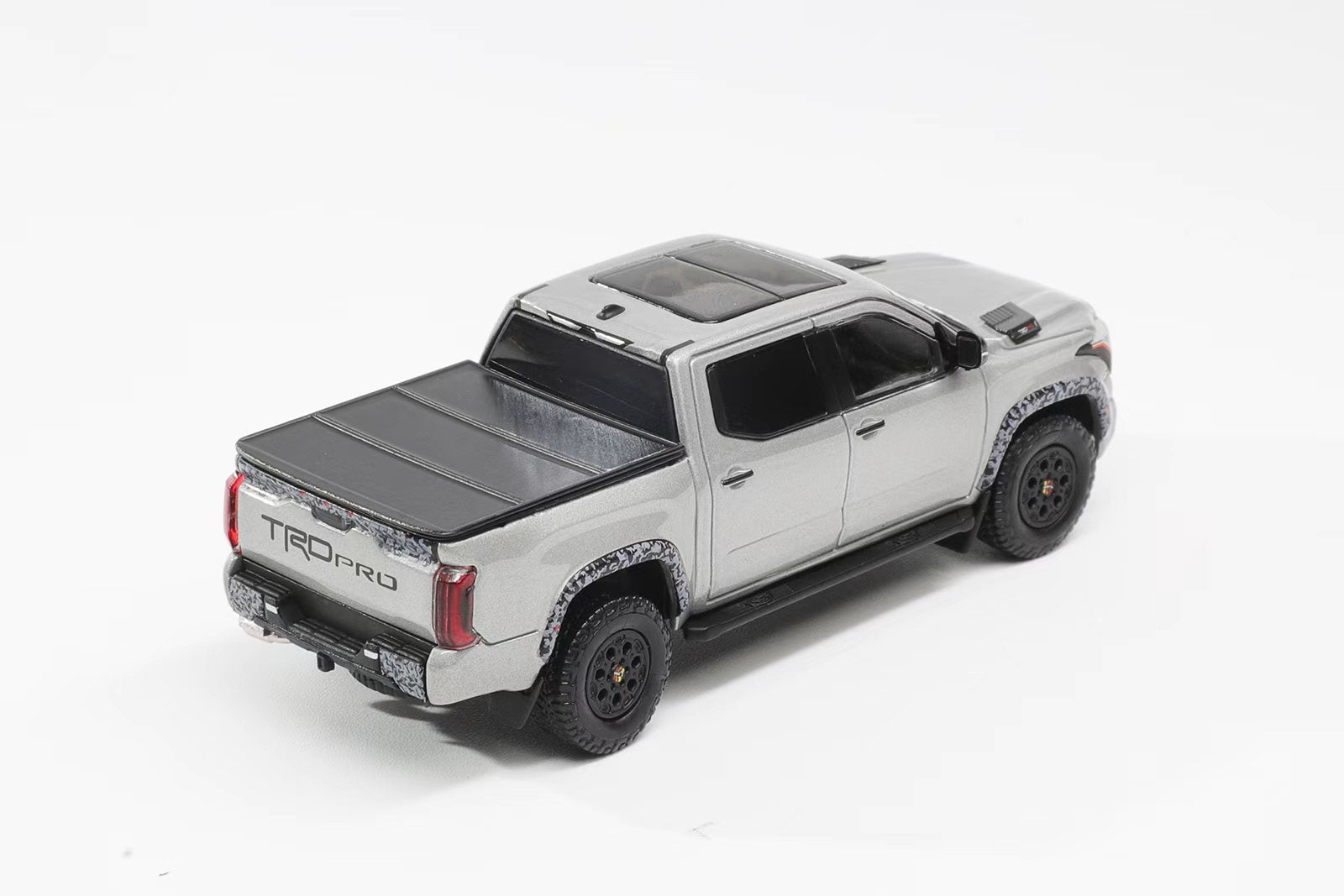 Model of a silver truck with a TONPROR cover on a white background