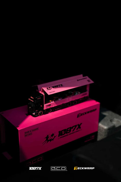 A pink and black 1087X branded miniature model truck displayed on top of its matching pink packaging box against a dark background.