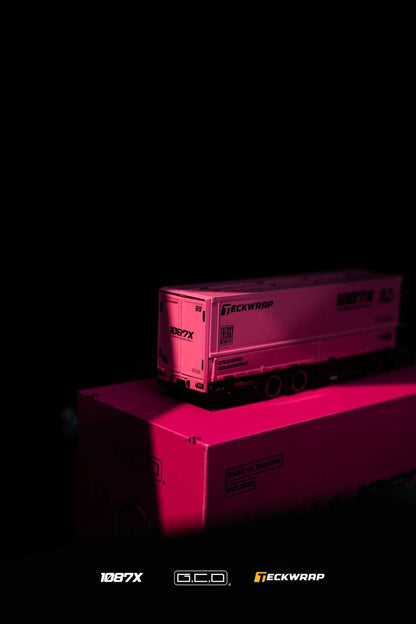 A small model semi-trailer truck with 'ECKWRAP' branding sits on top of its matching pink display box against a black background, lit dramatically with pink light.