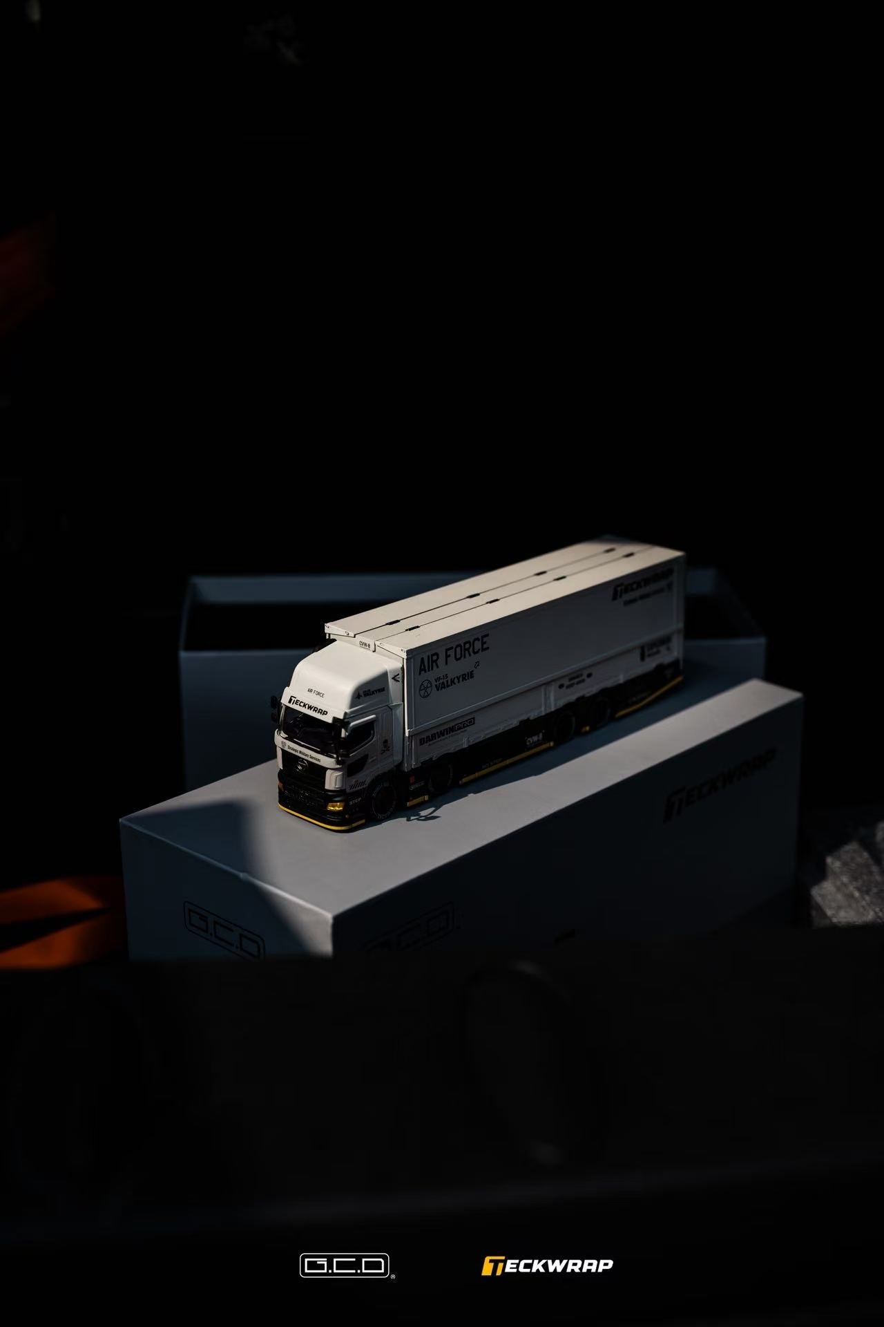 Hino Profia 700 DarwinPro &TECKWRAP Combat Grey truck on a box with 'Teckwrap' and 'GCD' branding in a dark setting