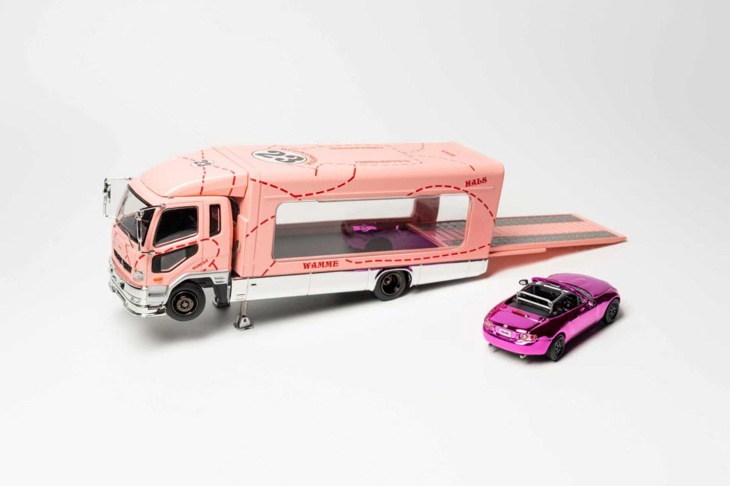 A pink and white toy car transporter truck with a ramp, shown alongside a small metallic pink and purple sports car on a clean white background.