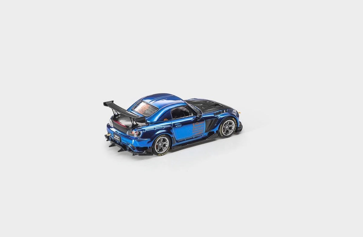 A blue and black diecast model car with a rear spoiler, photographed on a clean light gray background.