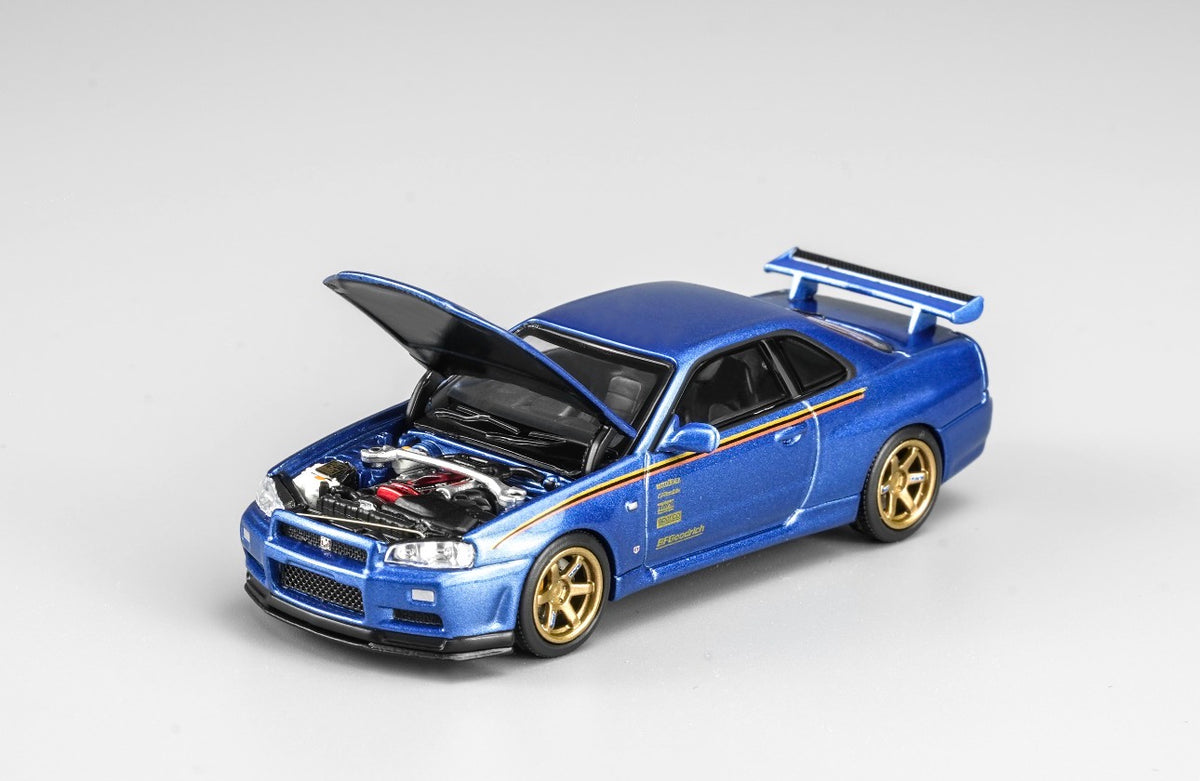 MotorHelix Nissan Skyline GT-R R34 1:64 diecast model in metallic blue, Hong Kong Toycar Salon 2026 exclusive M63453DZ-PT, opening hood with detailed engine bay, gold wheels, side graphics and rear wing.