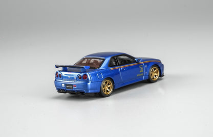 MotorHelix Nissan Skyline GT-R R34 1:64 diecast model in metallic blue, Hong Kong Toycar Salon 2026 exclusive M63453DZ-PT, rear three-quarter view with gold wheels, side graphics, rear wing and dual exhaust.