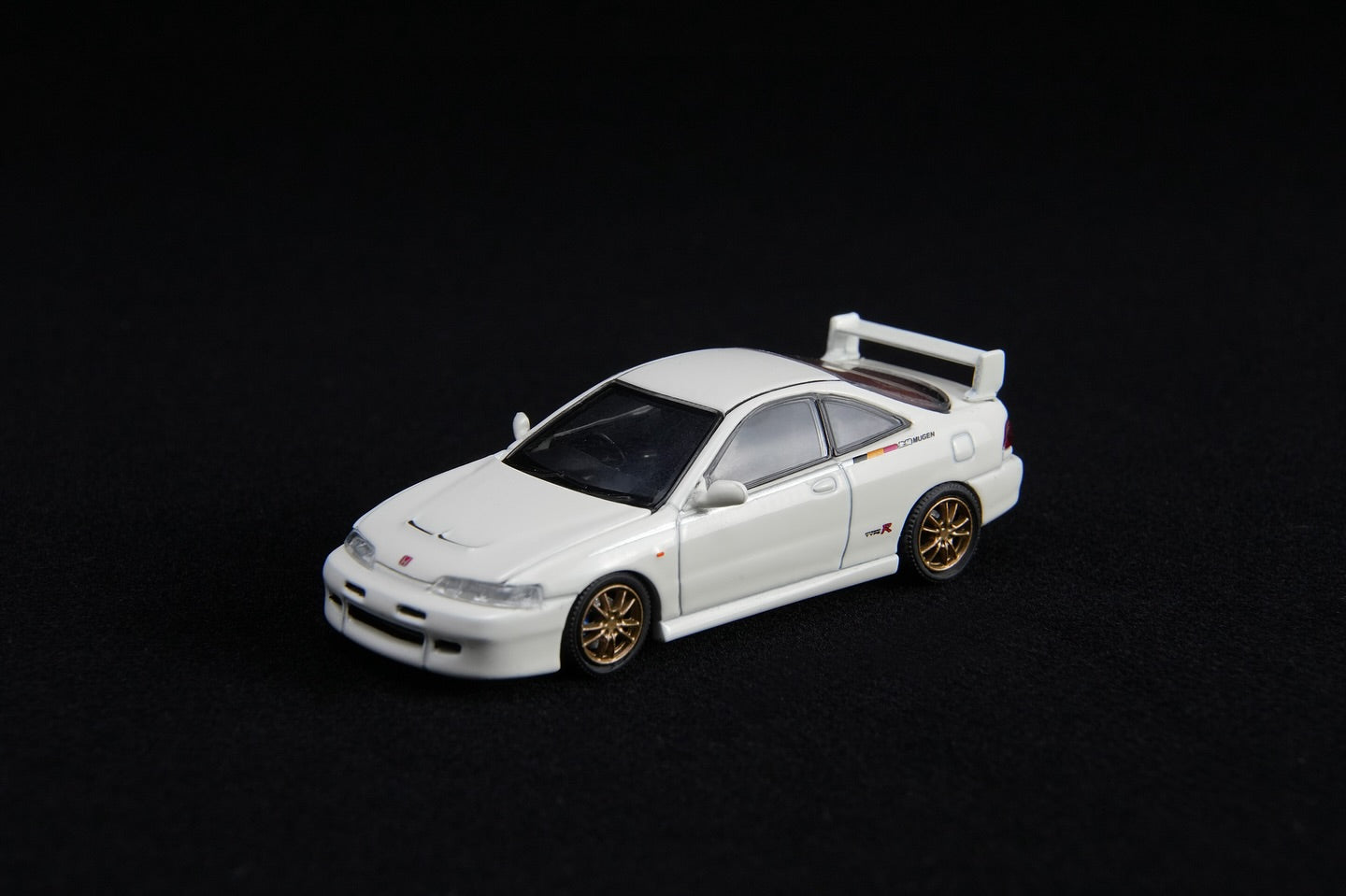 White model car with gold wheels on a black background
