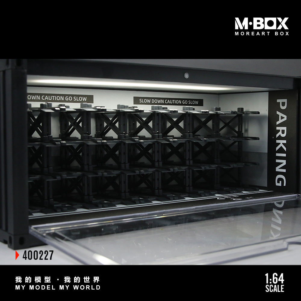 Model parking garage with crates labeled 'PARKING' and 'OWN CAUTION GO SLOW', featuring M-BOX branding.