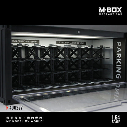 Model parking garage with crates labeled 'PARKING' and 'OWN CAUTION GO SLOW', featuring M-BOX branding.