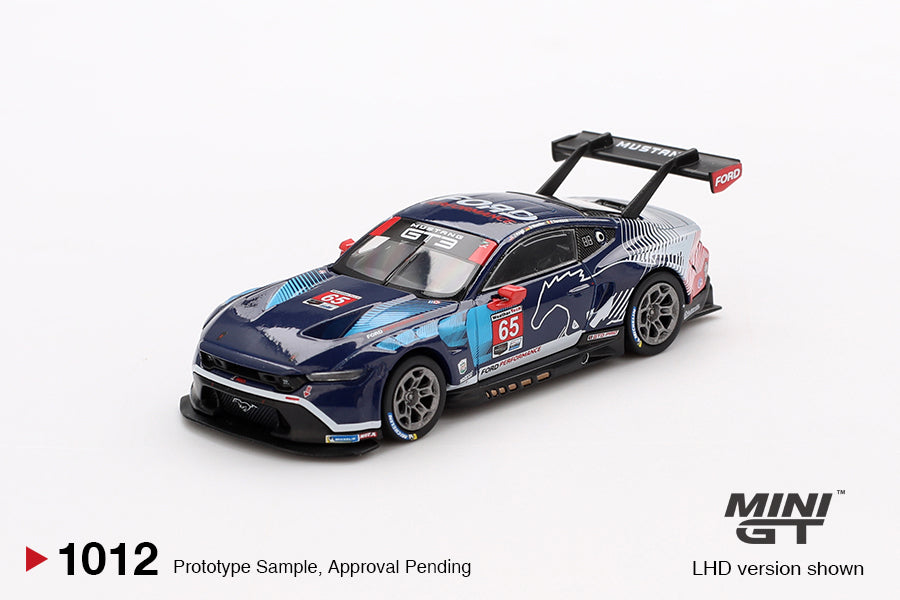 A 1:64 scale diecast model of a Ford Mustang GT3 in white and blue, representing the Ford Multimatic Motorsports team.