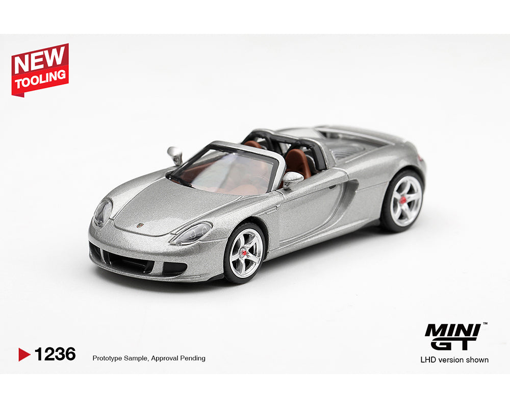 MINI GT MGT01236-BL Porsche Carrera GT GT Silver MiJo Exclusives 1:64 diecast model in GT Silver, shown from a front left three-quarter angle with brown interior, left-hand drive configuration and authentic Porsche detailing.