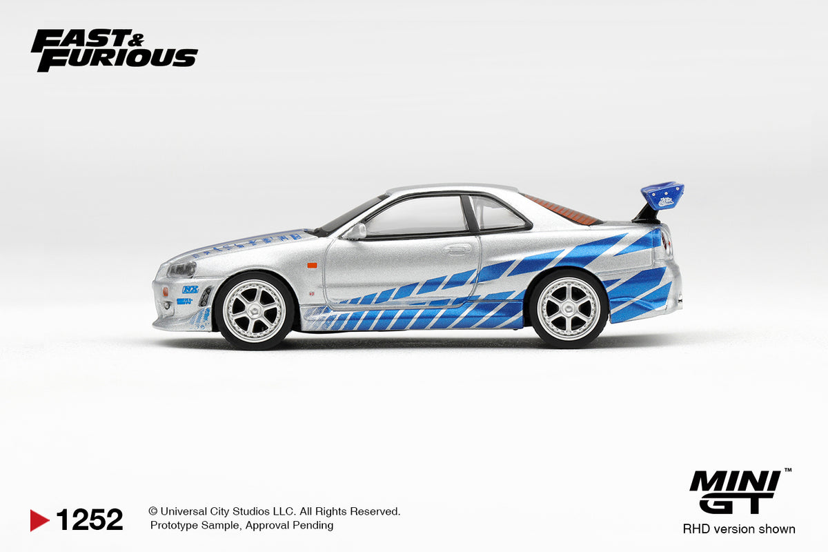 Mini GT 1:64 Fast & Furious Nissan Skyline GT-R R34 Silver MGT01252-BL diecast model car side profile with blue racing graphics and rear wing