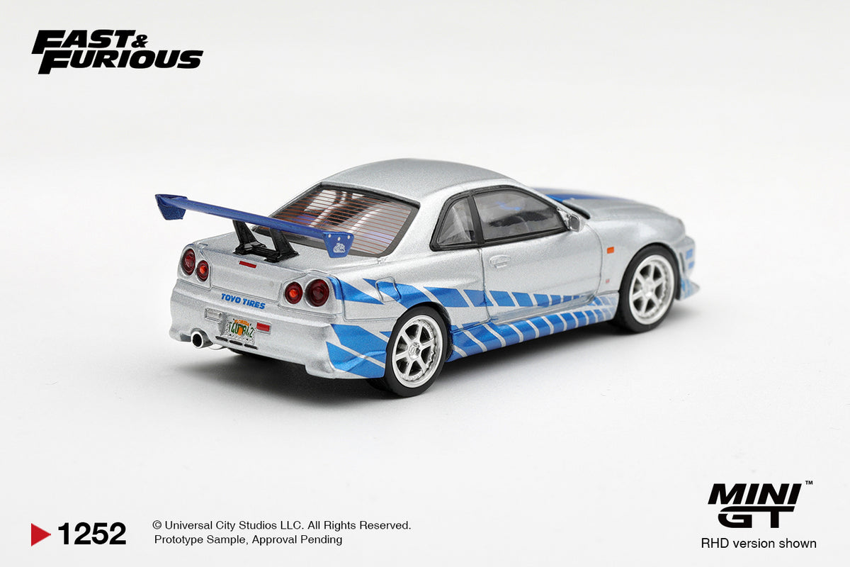 Mini GT 1:64 Fast & Furious Nissan Skyline GT-R R34 Silver MGT01252-BL diecast model car rear view with blue graphics, Toyo Tires branding and rear wing