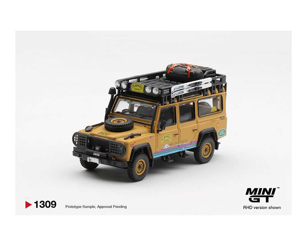 Model of a yellow SUV with roof racks and a spare tire on a white background, featuring the MINI GT logo.