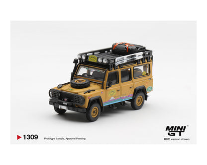 Model of a yellow SUV with roof racks and a spare tire on a white background, featuring the MINI GT logo.