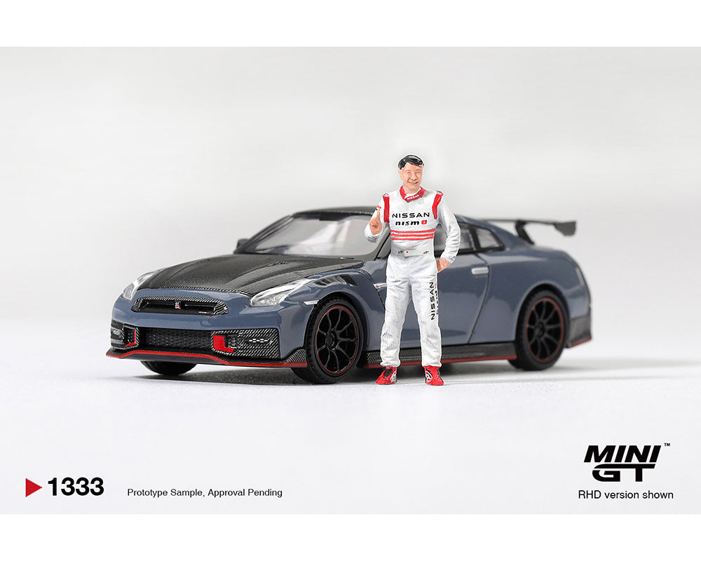 MINI GT MGT01333-R Nissan GT-R R35 NISMO Special Edition Stealth Gray with driver figure 1:64 diecast model, shown from a front left three-quarter view in right-hand drive configuration with carbon fiber hood, red NISMO accents, rear wing and authentic detailing.
