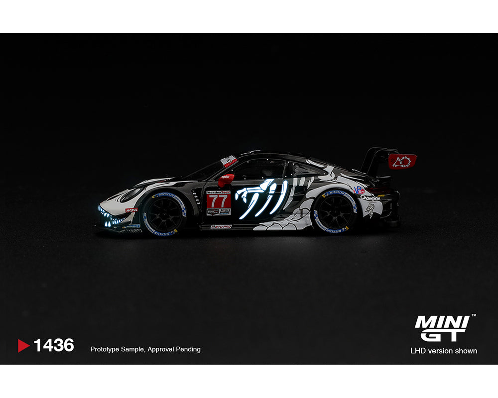 Mini GT 1:64 Porsche 911 GT3 R (992) #77 AO Racing Skeleton Rexy 2026 IMSA Petit Le Mans MGT01436-BL diecast model, side profile showing glow-in-the-dark blue skeleton graphics, black and white racing livery, Michelin tires and rear wing.
