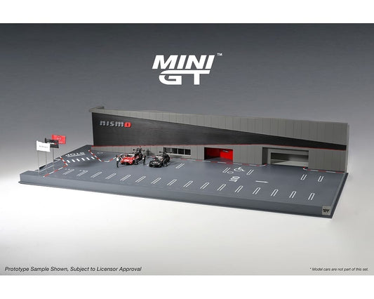 A 1:64 scale diorama of Nissan Motorsports Nismo Operation, featuring a grey structure with racing car figures on a grey surface.
