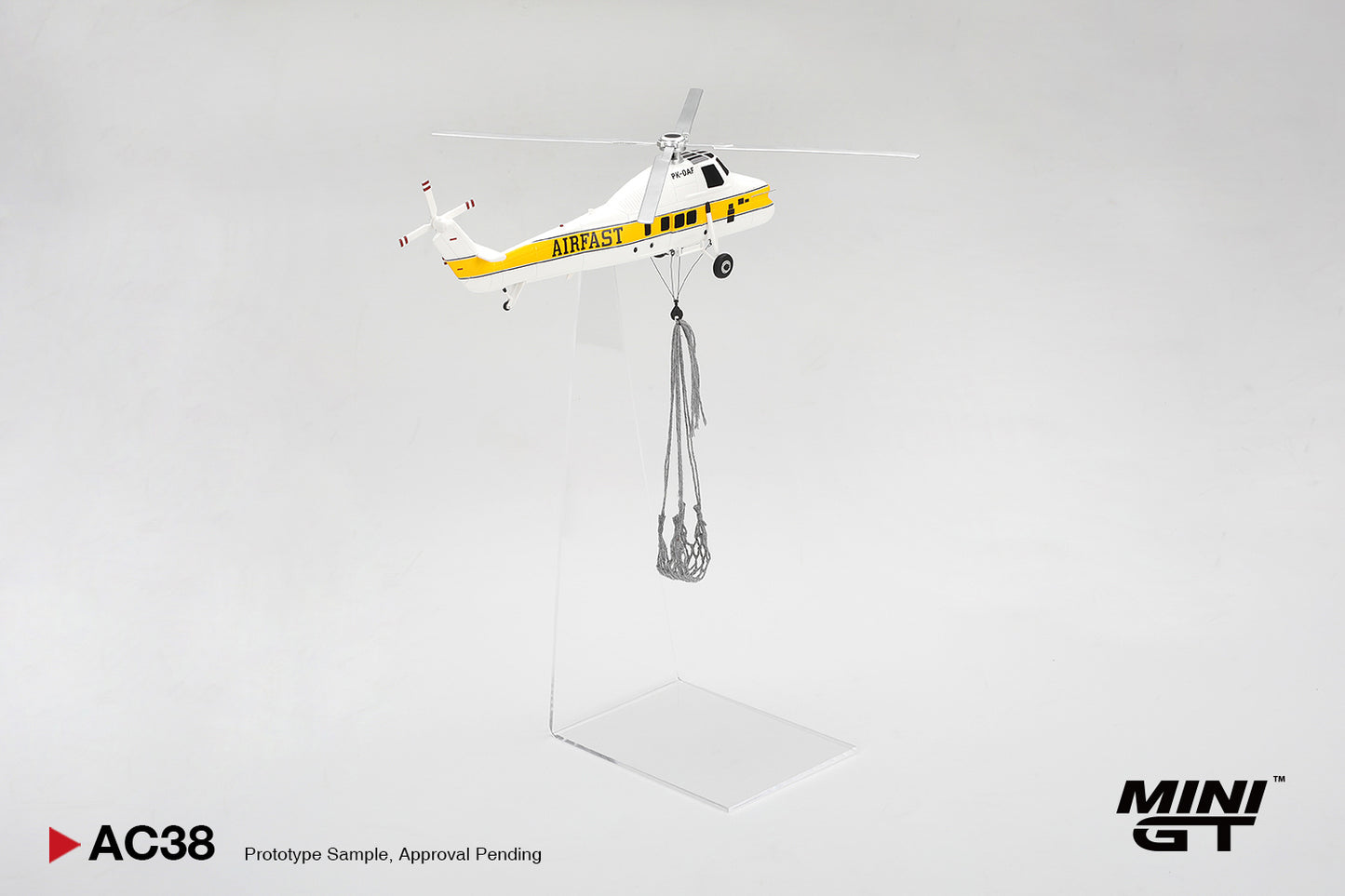 Model helicopter with a payload on a gray background, featuring the Mini GT brand.