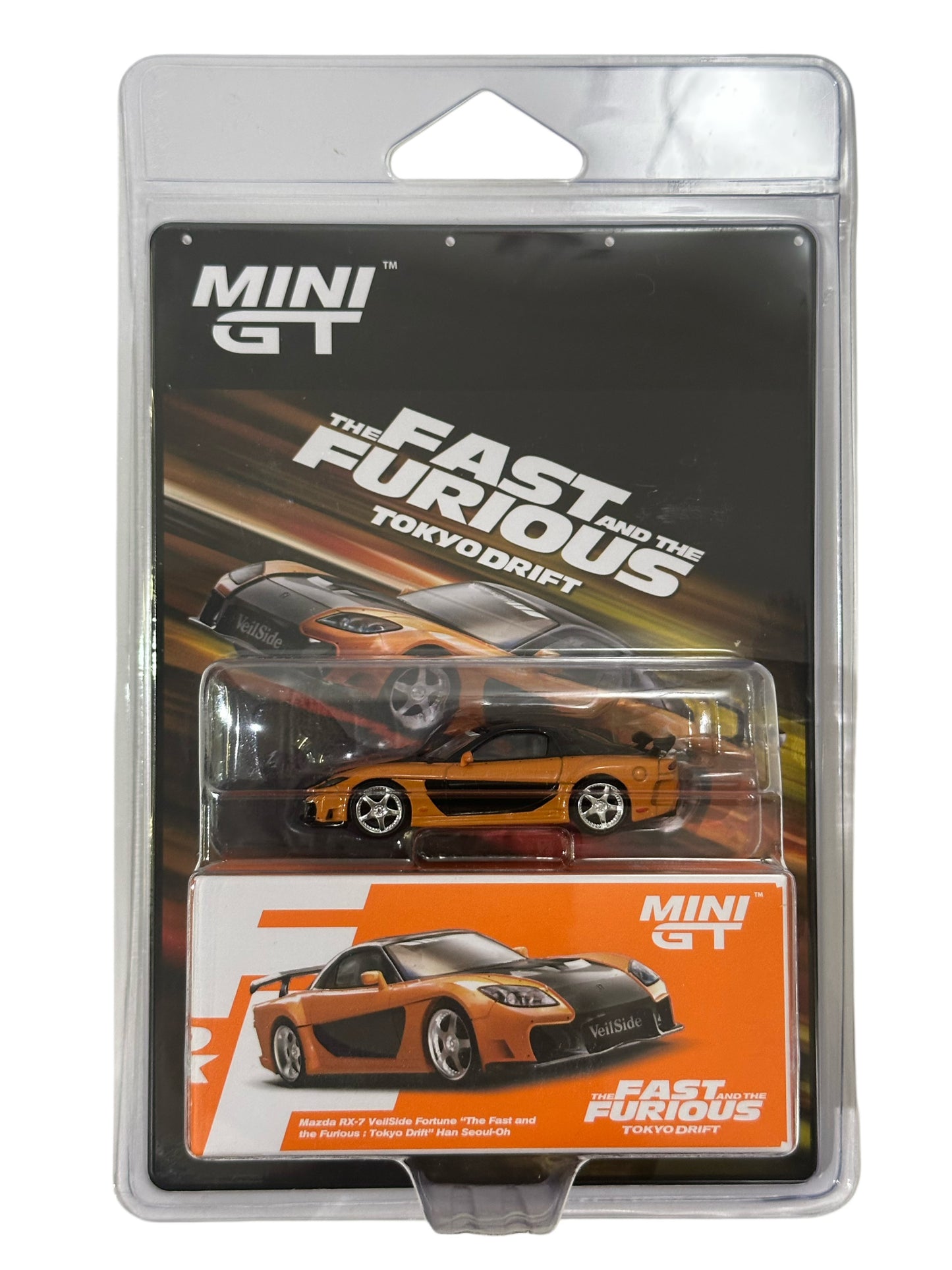 MINI GT The Fast and the Furious Tokyo Drift toy car in its original blister packaging, featuring an orange and black die-cast sports car on a black and orange backing card.
