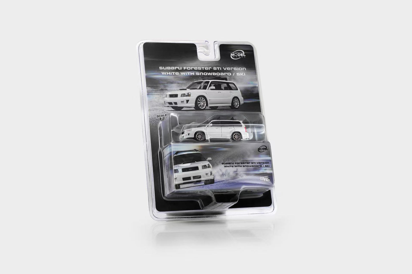 A packaged die-cast model car in a clear blister pack on a light gray studio background. The card backing shows a Subaru Forester 4x4 V7 concept car and text reading 'White with Snowboard / Ski'.