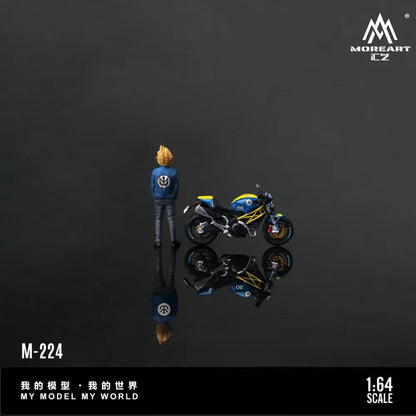 A 1:64 scale model figurine of a blonde character in a blue jacket standing next to a blue and yellow motorcycle, shown on a dark reflective surface with its reflection visible. The brand logo 'MOREART E-Z' is in the top right, and product text 'M-224' and '1:64 SCALE' is in the bottom.