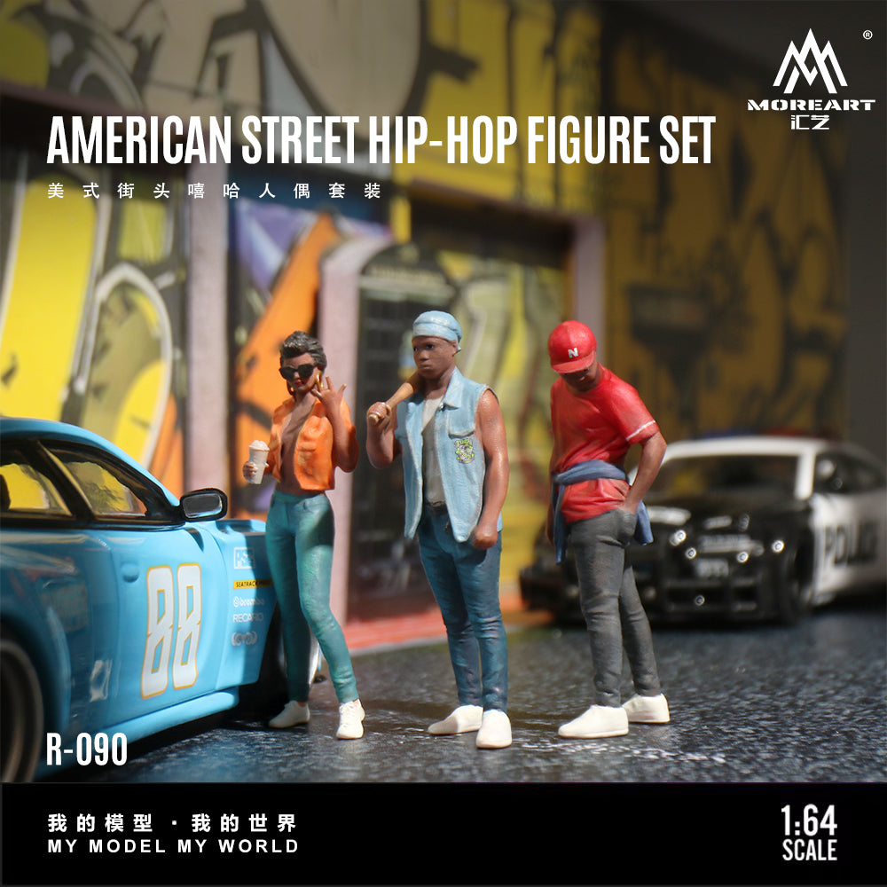 Model figures of three people in street fashion with a car and police car in an urban setting, featuring the brand 'MoreArt'.