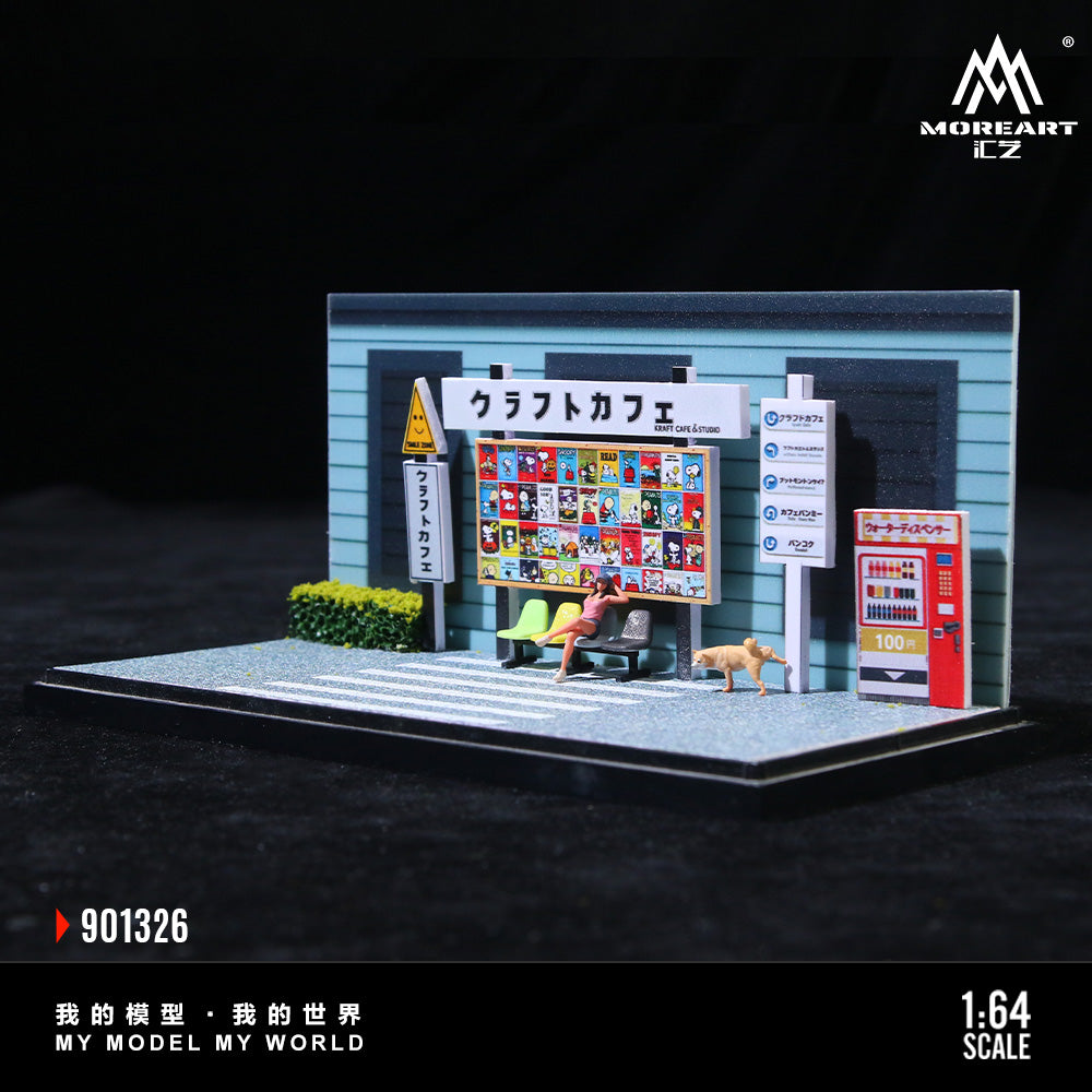 Model of a small cafe with a vending machine and person sitting on a bench, featuring MOREART branding.