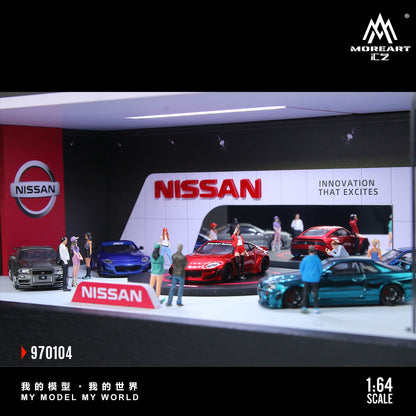 Model cars displayed on a scale model of a Nissan showroom with people around them.