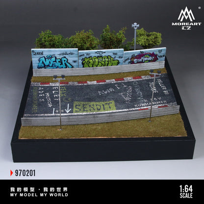 Model of a race track with cars and grass, featuring a brand logo.