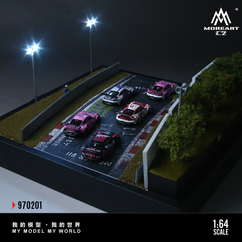 Model cars on a miniature racetrack with 'MoreArt CZ' branding.