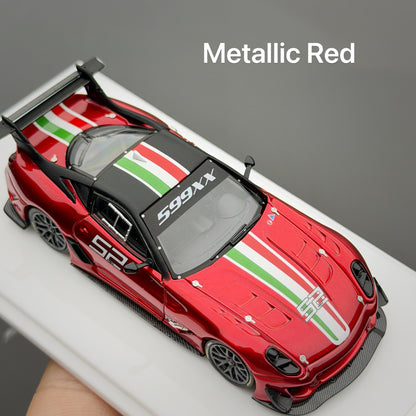 A metallic red diecast model car with green and white racing stripes, displayed on a white stand with a hand holding it at the bottom left.