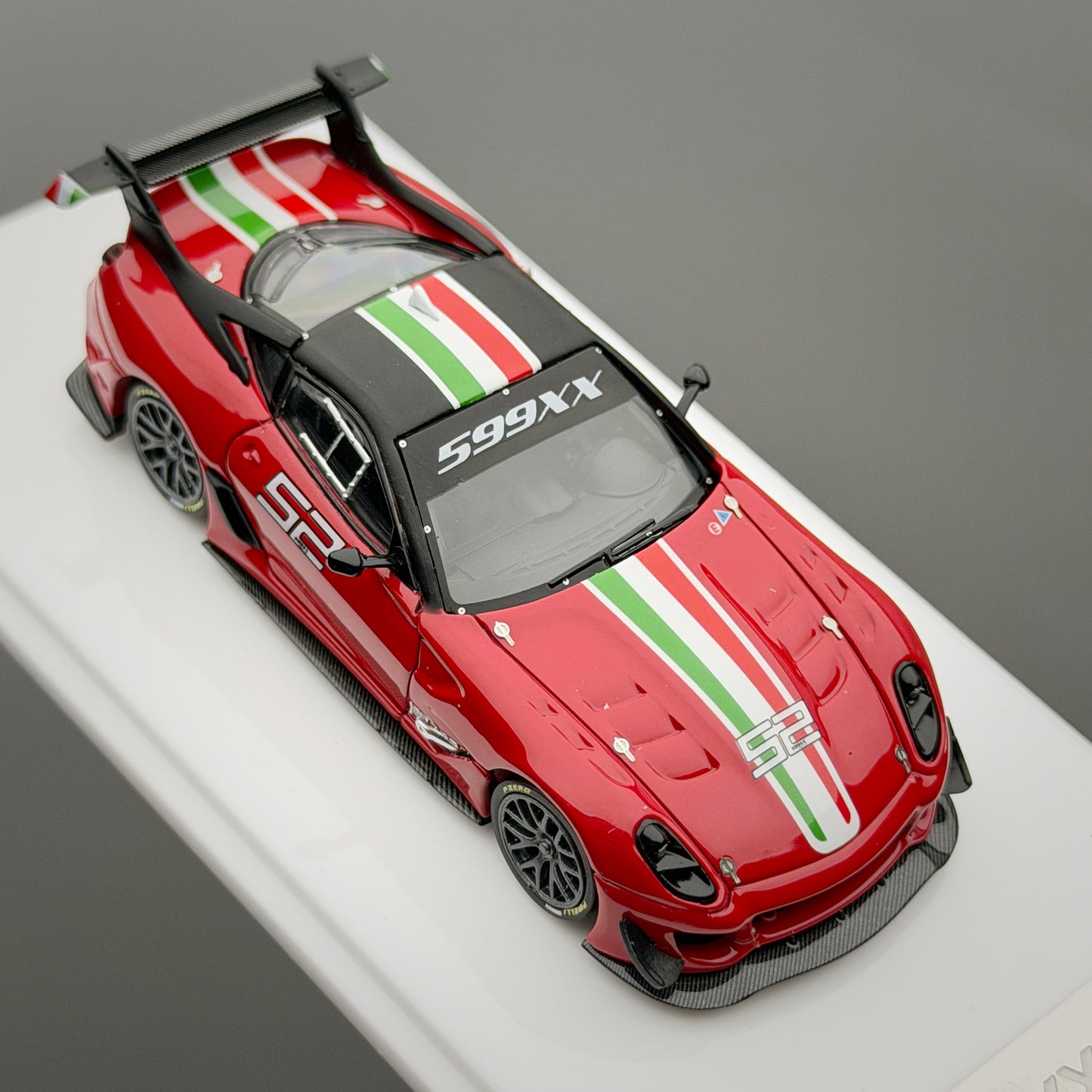 Red sports car model with Italian flag stripes on a gray background