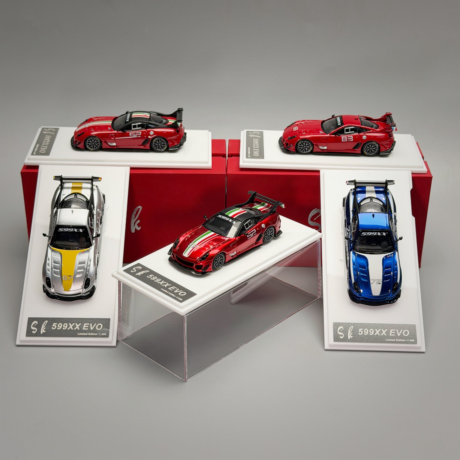 Collection of model cars on display with red, blue, and silver models.